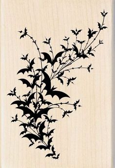 a rubber stamp with leaves and flowers in black ink on a white wooden background,