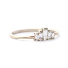 a three stone diamond ring on a white background