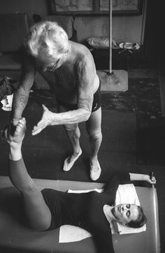 an older woman is doing exercises on a yoga mat with her leg up in the air