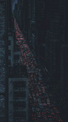 a city street filled with lots of traffic under a cloudy sky at night in the dark