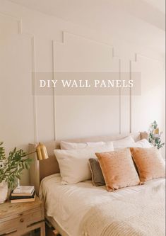 a white bed sitting next to a window with the words diy wall panels above it