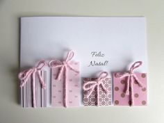 a card with pink and brown wrapping paper tied to it's sides, along with two matching envelopes