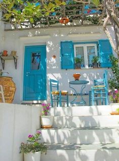 a house with blue shutters and potted plants