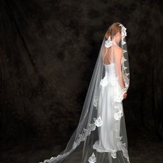 a woman wearing a wedding veil with flowers on it