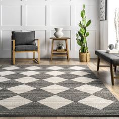 a living room area with two chairs and a rug on the floor in front of a white wall