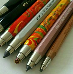 four different colored pencils sitting next to each other