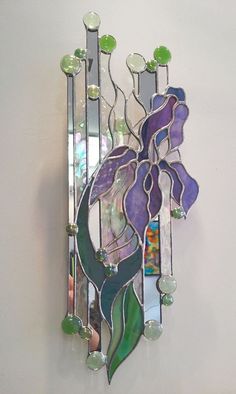 a stained glass flower is hanging on the wall