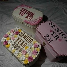 two decorated cakes sitting on top of a white sheet covered table next to each other