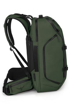 a green backpack sitting on top of a white floor next to a black handle bag