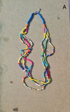 "Colorful vibrant multi beads multi-row summer necklace. This multi-layered multicolored necklace is made of mixed beads and seed beads and sequin beads. This Mexican multi-colored necklace is an ideal necklace for the Summer. The necklace is approx. 26\" long and has three rows. The drop length is approx. 13-14\". Available in two options: A - Blue beads B - White beads * The products are handmade and shipped from India. * Package preparation time is 1 - 2 business days. * Standard shipping - T Cheap Bohemian Rainbow Necklaces, Long Colourful Beaded Necklaces, Cheap Multicolor Long Necklace With Colorful Beads, Luxury Multicolor Single Strand Beaded Necklaces, Cheap Rainbow Necklaces With Colorful Beads, Cheap Rainbow Beaded Necklaces With Large Beads, Luxury Multicolor Necklace For Festivals, Summer Multi-strand Colorful Beaded Necklaces, Summer Multi-strand Beaded Necklaces