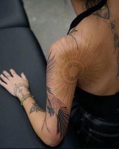 a woman with tattoos on her back and arm