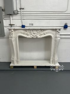 a white fireplace with blue piping on the top and bottom, in front of a wall