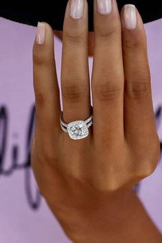 a woman's hand with a diamond ring on it