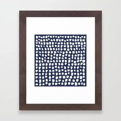 a blue and white framed art print with circles on the bottom, in a dark wood frame