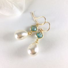 "Pearl Earrings, Gold Pearl Earrings, Pearl Dangle Earrings, Pearl Drop Earrings, Aquamarine Earrings, Aqua Pearl Earrings, Wedding Bridal Earrings, Bridesmaid Gift, Pearl Jewelry, Customizable Earrings, Custom Jewelry Stunning combination, these earrings are composed of a gold plated faceted square glass connector with a 10x17mm faux teardrop pearl dangling beneath and simply hung from gold tone copper ear wires. There are many different options available for these earrings including stone colo Aquamarine Earrings Wedding, Pearl Drop Dangle Jewelry For Bridal Shower, Dangle Pearl Drop Jewelry For Bridesmaids, Dangle Earrings For Bridesmaid Gift, Teardrop Pearl Drop Jewelry For Bridal Shower, Gold Gemstone Pearl Earrings For Wedding, Pearl Drop Dangle Earrings For Bridal Shower, Drop Earrings For Bridesmaid Gift, Teardrop Pearl Drop Jewelry For Bridesmaid Gift