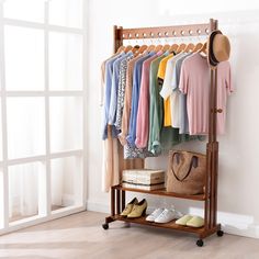 a rack with clothes and shoes on it in front of a wall mounted coat rack