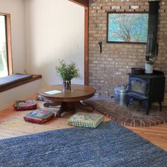 a living room with wood burning stove and blue rug