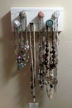 there are many different necklaces hanging on the wall next to a light switch box