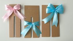 three pieces of cardboard with blue and pink bows on them