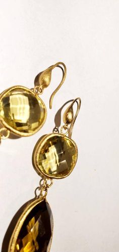 These vintage earrings are quite stunning and just what you need for special occasions. They feature faceted round and teardrop shaped smoky and yellow quartz in gold settings that catch the light just perfectly. They dangle from gold-toned ear wires. From the top of the wire to the bottom of the pearl, they measure 3 inches. These earrings are in very good vintage condition. Thanks for visiting my vintage jewelry store! Back to my shop here: https://www.etsy.com/shop/RemembrancesofYours Elegant Gold Teardrop Earrings With Gemstone, Gold Teardrop Gemstone Earrings For Wedding, Gold Teardrop Earrings With Gemstone For Anniversary, Gold Teardrop Gemstone Earrings, Gold Gemstone Teardrop Earrings For Formal Occasions, Gold Briolette Earrings Nickel Free, Vintage Gold Gemstone Earrings, Gold Faceted Drop Earrings, Gold Citrine Drop Jewelry