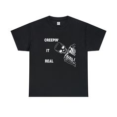 "\"Embrace the spooky spirit of Halloween with our 'Creepin' It Real' t-shirt featuring a mischievous skeleton lurking in the shadows. This bone-chilling design combines humor and Halloween vibes, perfect for those who love to embrace the creepy side of life.  The unisex heavy cotton tee is the basic staple of any wardrobe. It is the foundation upon which casual fashion grows. All it needs is a personalized design to elevate things to profitability. The specially spun fibers provide a smooth sur Cotton Horror T-shirt With Skull Print, Funny Halloween Streetwear T-shirt, Funny Halloween T-shirt For Streetwear, Spooky Skull Graphic Print Tops, Halloween Novelty T-shirt For Streetwear, Novelty Halloween T-shirt For Streetwear, Spooky Cotton T-shirt With Skull Print, Spooky Skull Print T-shirt For Streetwear, Spooky Letter Print T-shirt For Streetwear