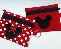 two red and white polka dot bags with mickey mouse ears on the front one has a key chain attached to it