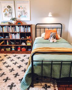 a bedroom with a bed, bookshelf and rug