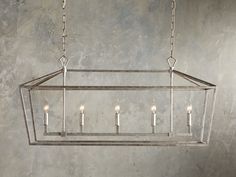 a rectangular chandelier with five candles hanging from the bottom and four lights on each end