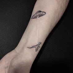 a person with a small tattoo on their arm that has an image of a shark and a fish