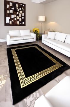 a living room with white couches and black rug