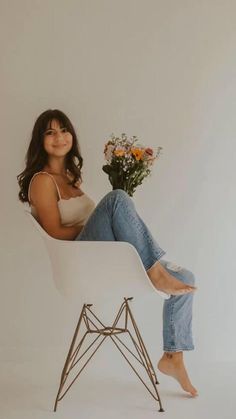 a woman sitting in a white chair with flowers