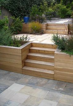 an outdoor garden with wooden steps and planters on the sides, surrounded by greenery