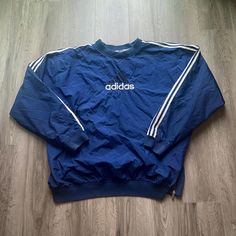 Vintage 1990s Adidas Windbreaker Jacket  - Size XXL (Length 29.5", Chest 28") - Overall great vintage condition (small stains pictured) - Message for more information Please take note of the measurements listed as these are vintage clothes and may fit different than the tag size. Follow our page for more vintage clothing drops! DISCLAIMER: All items are vintage so please be mindful that if by chance there is a flaw on the item we simply may have just missed it. Inquire for more product informati Adidas 90s Coat, Retro Oversized Crew Neck Outerwear, 90s Inspired Long Sleeve Fall Outerwear, 90s Style Fall Windbreaker For Streetwear, 90s Inspired Long Sleeve Streetwear Outerwear, 90s Style Sports Outerwear With Crew Neck, 90s Crew Neck Outerwear For Fall, 90s Style Outerwear With Crew Neck For Fall, 90s Style Long Sleeve Track Jacket For Fall