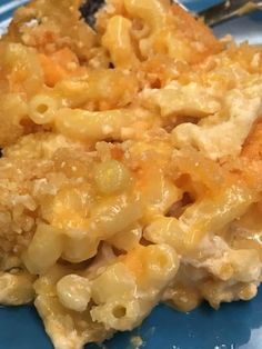 macaroni and cheese casserole on a blue plate with a silver fork