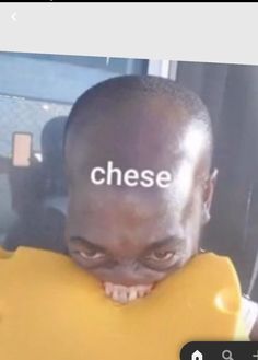 a man holding up a large yellow object with the word cheese on it's forehead