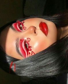 a woman with black hair and red makeup has her face painted like a demon or devil