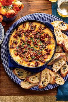 a blue plate topped with bread slices and a bowl filled with food next to it