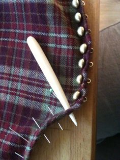 a close up of a piece of cloth with pins and needles sticking out of it