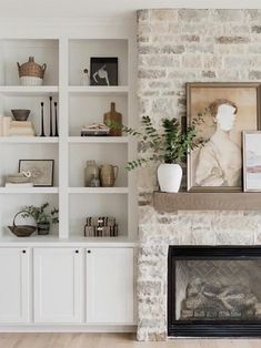 a living room filled with furniture and a fire place in front of a brick wall