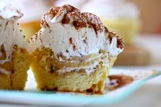 two cupcakes with white frosting sitting on a plate