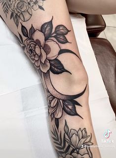 a woman's arm with flowers on it and a crescent in the middle is shown