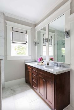 a bathroom with double sinks and large mirrors