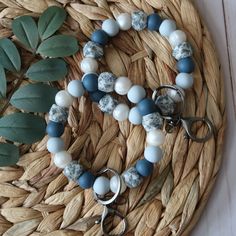 a blue and white beaded bracelet on a wicker basket next to green leaves