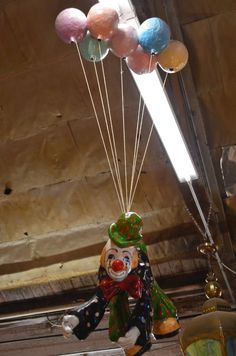 a bunch of balloons that are hanging from the ceiling in front of a light fixture