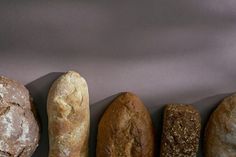 five different types of breads lined up in a row on a gray background,