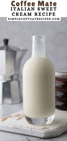 a bottle of milk sitting on top of a counter next to a cup of coffee