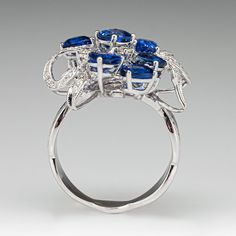 This wonderful cluster style ring is accented with five (5), prong set, oval mixed cut natural sapphires, one (1), prong set, pear mixed cut natural sapphire and one (1), prong set, triangular mixed cut natural sapphire. The sapphires are bordered with three (3), prong set, round brilliant cut diamonds and forty- nine (49), bead set, round brilliant/single cut diamonds, bordered with milgrain edging. Engraved details accent the shoulders of the shank. The ring measures 17.9mm at the top, rises 9.9mm above the finger, tapering to 3.3mm wide and 1.1mm thick at the base of the shank. This ring is currently a size 6.75. Blue Sapphire Diamond, Bead Set, Diamond Cocktail Rings, Diamond Cluster Ring, Natural Sapphire, Brilliant Diamond, Diamond Cluster, Sapphire Diamond, Cluster Ring