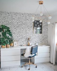 a white desk with a black chair in front of it and a leopard print wallpaper behind it