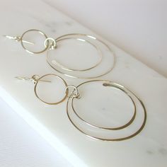 "Swinging circles and semi circles create these fun and unique earrings. Shown in sterling silver, also available in 14k gold fill and rose gold fill. Measure approximately 3\". All of my jewelry is made with sterling silver and gold fill wire and findings, nothing is plated and the craftsmanship is guaranteed, so feel secure in purchasing these earrings for yourself or as a special gift. I guarantee all of my work. All orders come packaged ready for gift giving. In order to keep down on waste, Modern Dangle Hoop Earrings For Anniversary, Modern Anniversary Dangle Hoop Earrings, Modern Nickel-free Open Circle Hoop Earrings, Modern Circular Hoop Earrings For Anniversary, Modern Circle Hoop Earrings For Anniversary, Modern Hoop Earrings For Anniversary, Modern Anniversary Hoop Earrings, Geometric Hoop Earrings, Crafting Materials