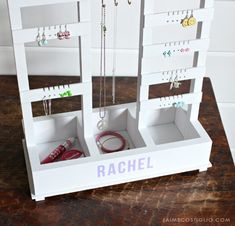 a jewelry rack with several necklaces hanging from it's sides on a wooden table